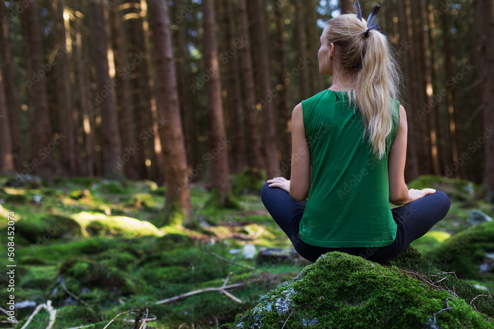 Woman sitting in green forest enjoys the silence and beauty of nature. Woman sitting in green forest enjoys the silence and beauty of nature.