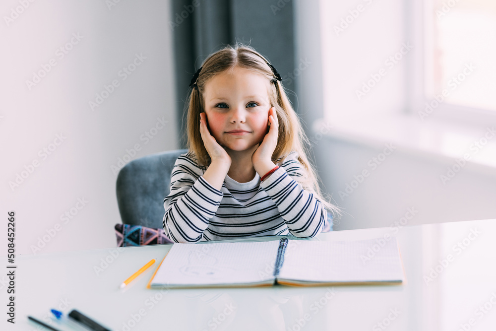 Unhappy little Caucasian girl child sit at table at home feel lazy unmotivated doing homework assignment. Upset distressed small kid prepare school task, learn study with books. Education concept. Unhappy little Caucasian girl child sit at table at home feel lazy unmotivated doing homework assignment. Upset distressed small kid prepare school task, learn study with books. Education concept.