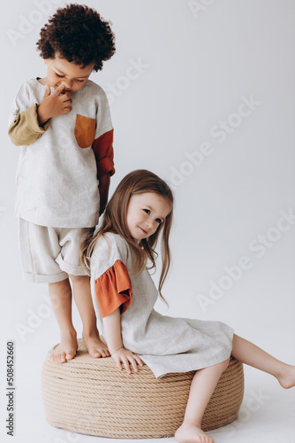 Fotografie Photos of children having fun and posing for a photo in summer linen clothes in a photo studio