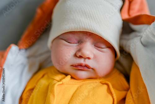 Newborn baby sleeps in a hat after a walk