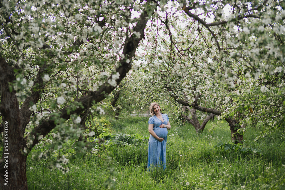 Middle-aged beautiful pregnant woman dreaming about child outdoors. Happy expectant thinking about baby and enjoying her future life. Motherhood, pregnancy, happiness, health care concept, copy space.