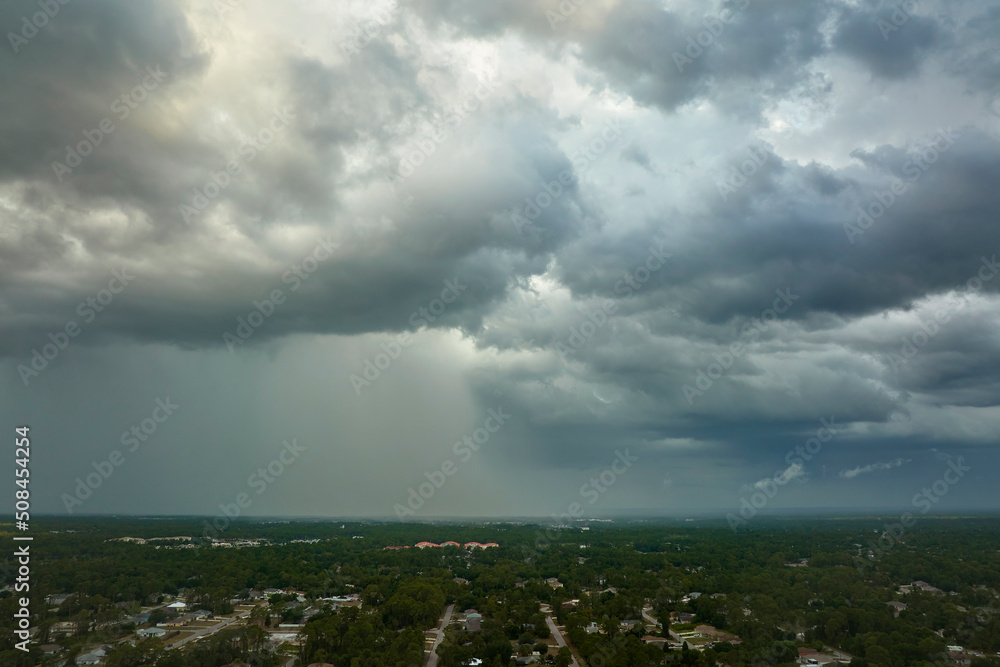 Landscape of dark ominous clouds forming on stormy sky before heavy thunderstorm over rural town area