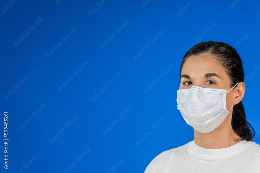 Isolated Woman wearing protective mask against blue background, copy space Isolated Woman wearing protective mask against blue background, copy space