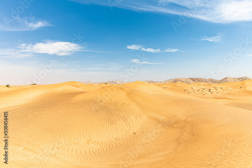 Sand Dunes landscape with Mountains in the background and with blue sky with large copy space