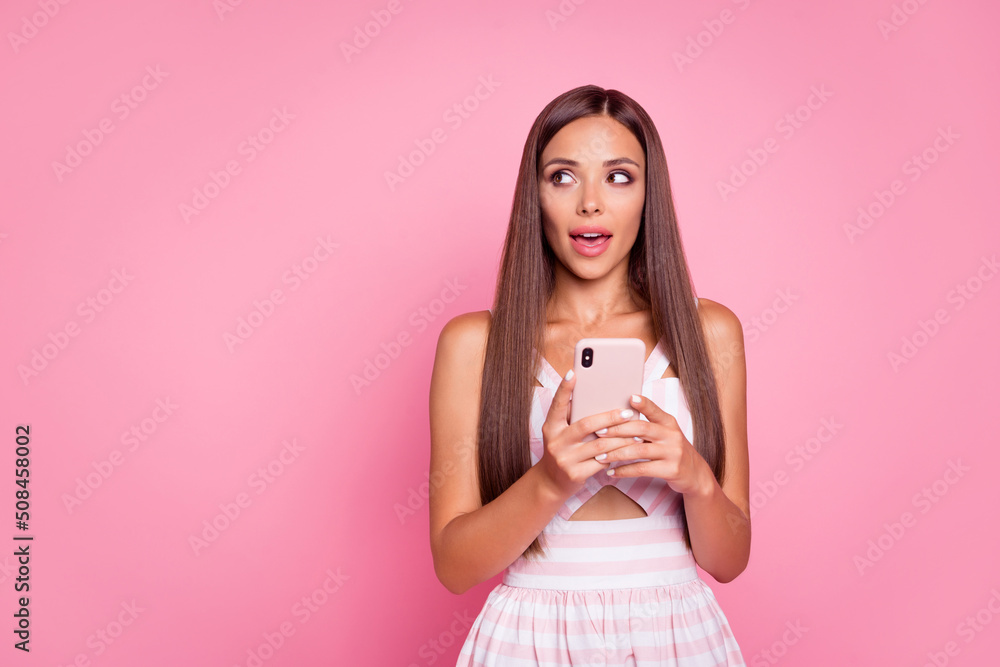 Photo of dreamy thoughtful woman wear striped dress typing modern device empty space isolated pink color background Photo of dreamy thoughtful woman wear striped dress typing modern device empty space isolated pink color background
