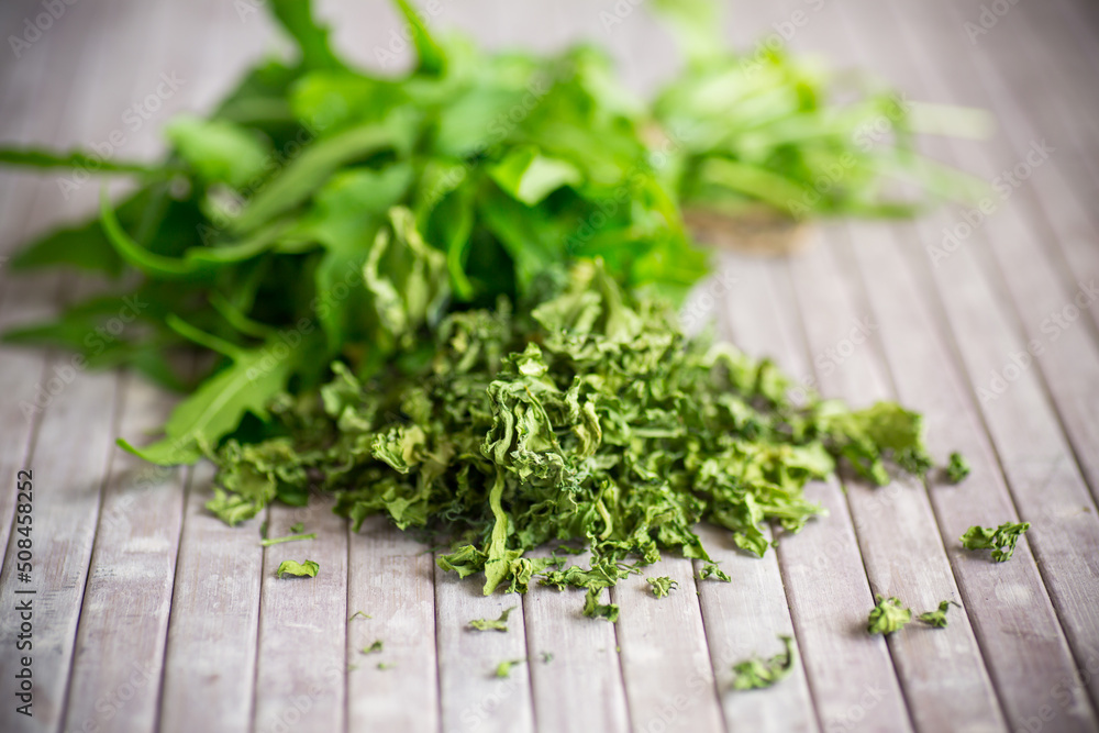 dried green organic arugula on wooden table dried green organic arugula on wooden table