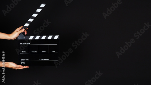 Photo Hand's holding Clapperboard or movie slate use in video production ,film, cinema industry on black background