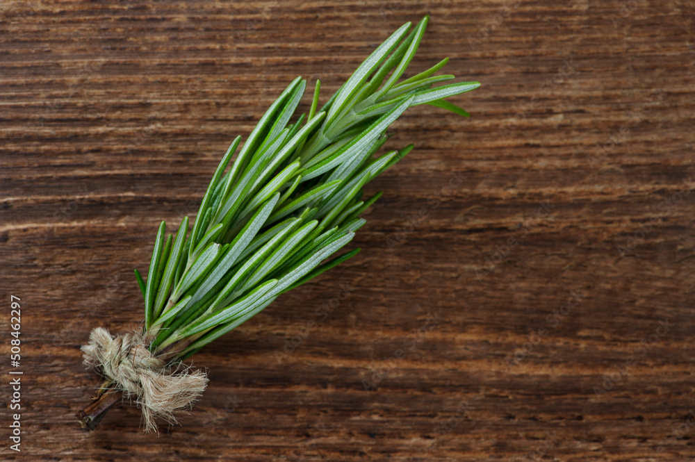 Rosemary plant on wooden background from above, bundle of fresh herbs with copy space for text. Rosemary plant on wooden background from above, bundle of fresh herbs with copy space for text.