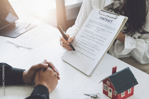 Fotografiet Guarantee, Mortgage, agreement, contract, Signing, Male client holding pen to reading agreement document to sign land loan with real estate agent or bank officer