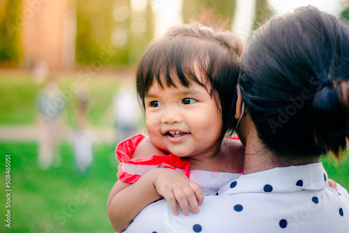 happy little asian girl cheerful with big smile in park funny adorable with mother