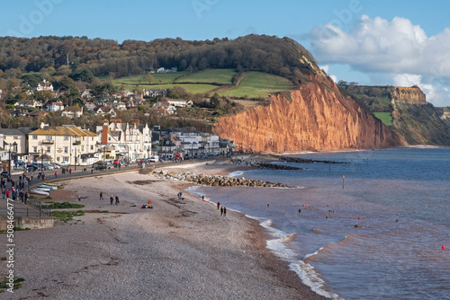The pebble beach at Sidmouth, Devon UK  is a popular attraction for locals and holidaymakers alike. It is seen here against the sandstone cliffs of Pennington Point in the background photo