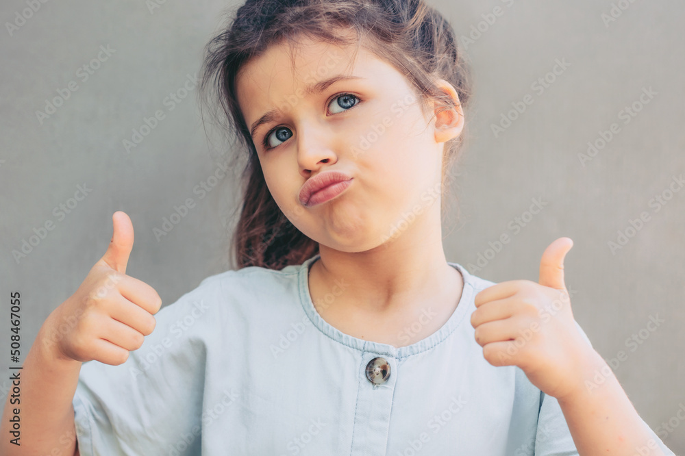 Narcissistic child girl proud of herself, schoolgirl shows thumbs up gesture.I am glamorous and cool Narcissistic child girl proud of herself, schoolgirl shows thumbs up gesture.I am glamorous and cool