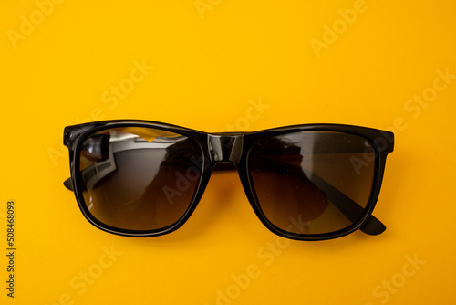 Black s sunglasses on orange background