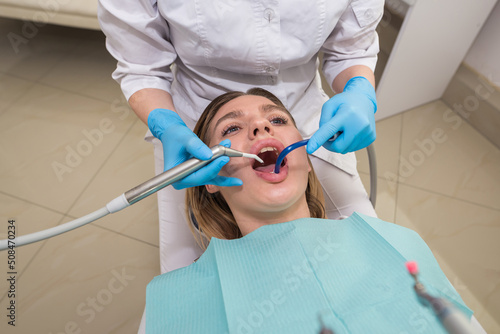 A young female dentist fills a patient s tooth. Visiting an orthodontist.