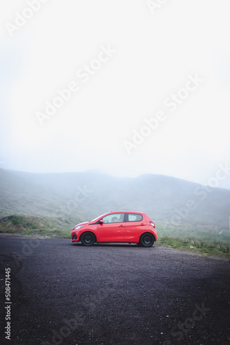 Fototapeta Naklejka Na Ścianę i Meble -  Red car in nature with fog, Azores