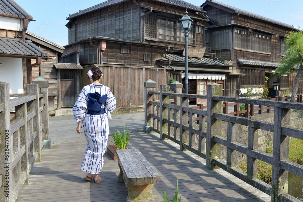 Obraz premium 小江戸佐原の町並みを歩く浴衣を着た若い女性の後ろ姿