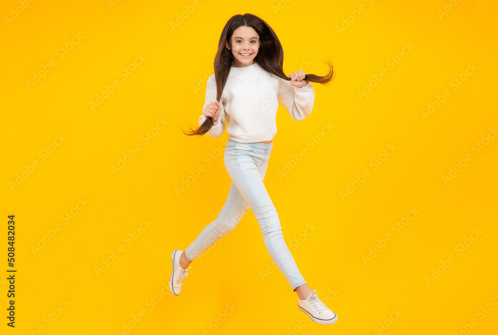 Happiness, freedom, motion and child. Young teenager girl jumping in air over yellow background. Happiness, freedom, motion and child. Young teenager girl jumping in air over yellow background.