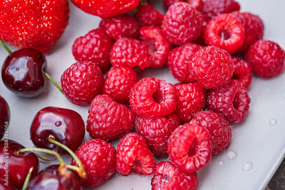 A plate of summer fruit. A close-up of raspberries on a plate. A plate of summer fruit. A close-up of raspberries on a plate.
