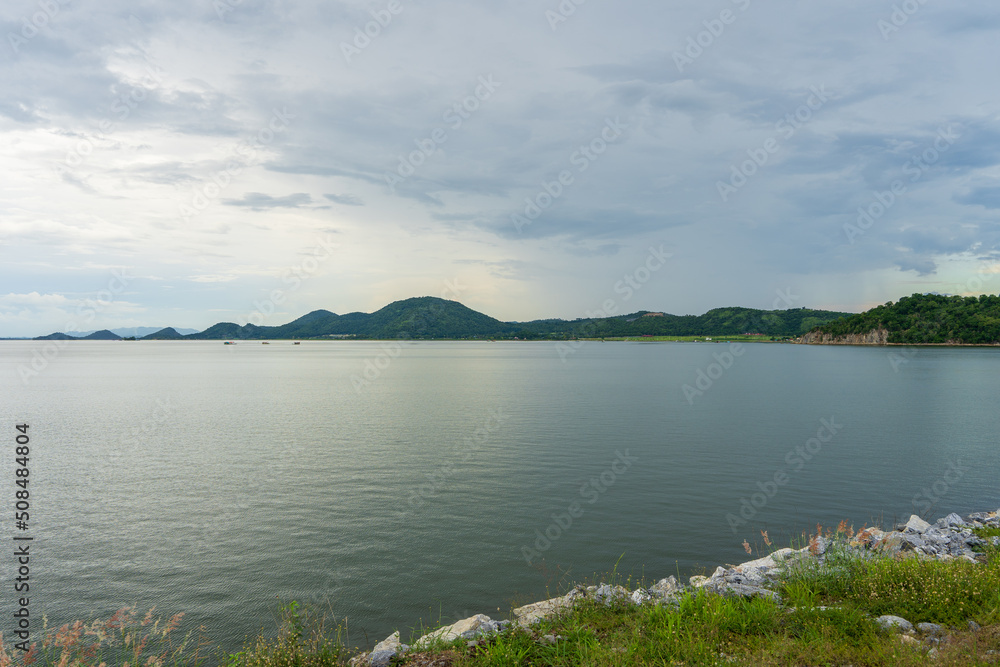 Beautiful view of the reservoir dam surrounded by mountains in Kanchanaburi Province, Thailand.