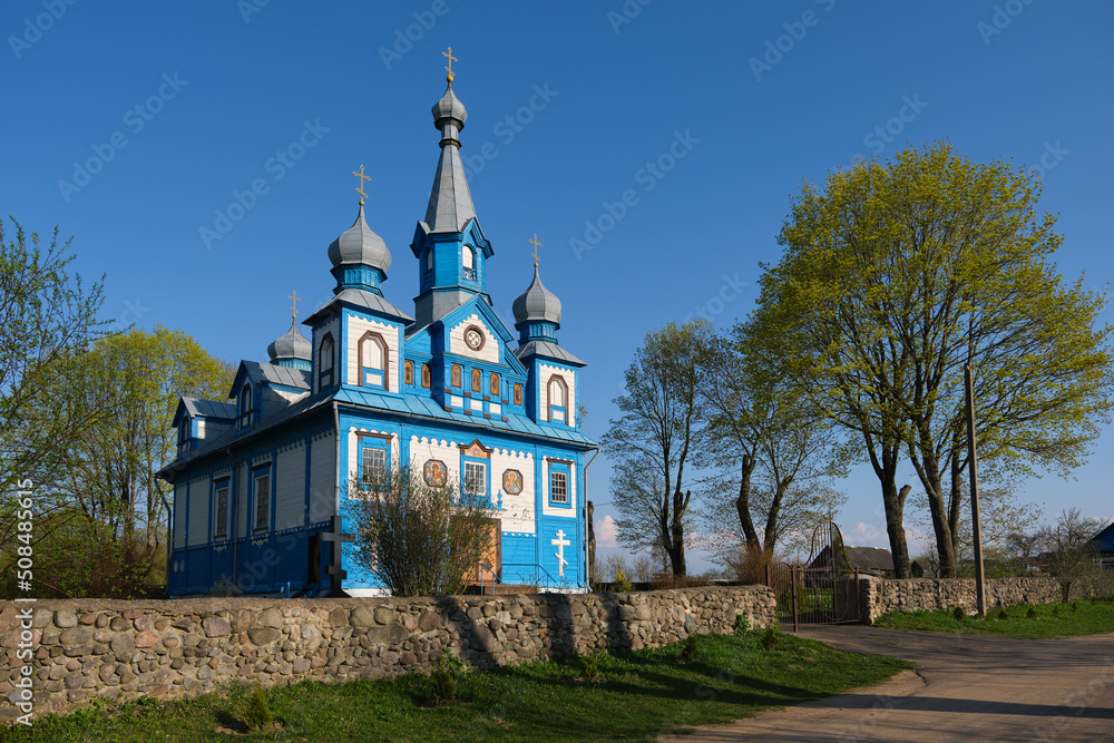 Naklejka premium Old ancient wooden church of the Holy Life Giving Trinity in spring, Telyadovichi, Kopyl district, Minsk region, Belarus.