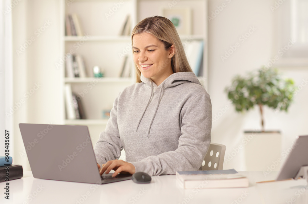 Young casual female sitting in front of a laptop computer at home Young casual female sitting in front of a laptop computer at home