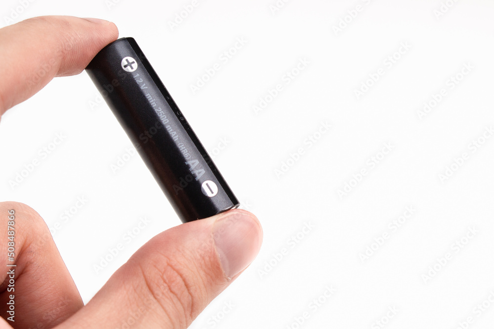 Hand holding a battery over white background with copy space. Hand holding a battery over white background with copy space.