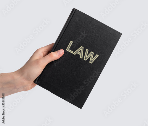 Woman hand with law book. Code, legal dictionary, guide. Education, studying information for becoming lawyer concept. Literature for attorney work. High quality photo