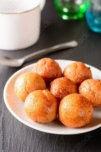 fried semolina balls on a plate, served savory treat and light snack for tea time, closeup view of a sweet balls taken in shallow depth of field