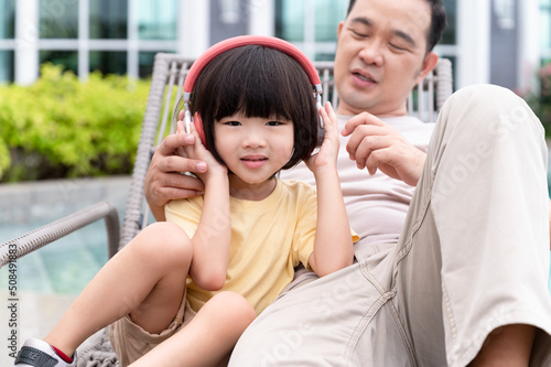 Father with cute son use headphone at outside home  © chachamp