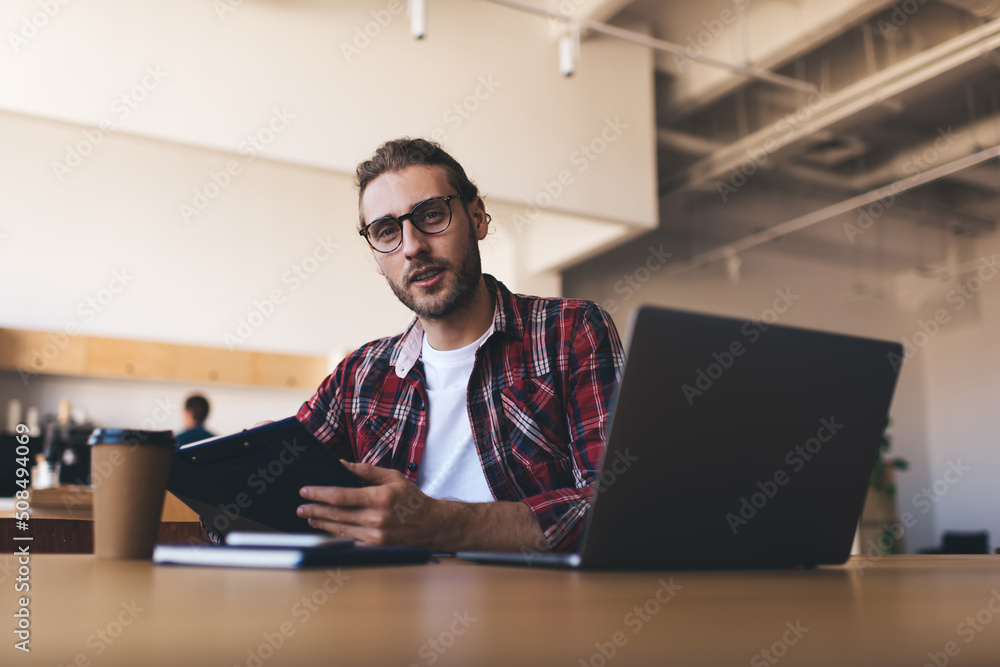 Millennial businessman working at desk in office Millennial businessman working at desk in office