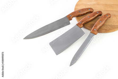 Set of professional kitchen knives on wooden board and dark background with copy space.