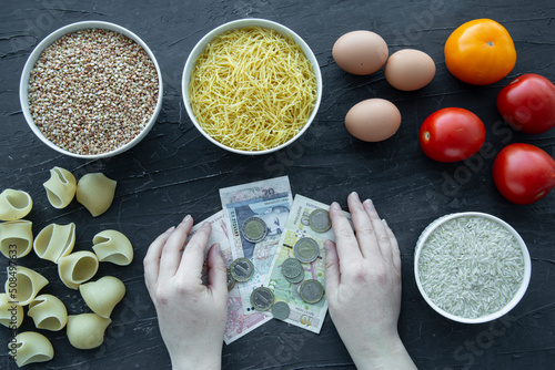 High costs of every day products in Bulgaria. Female hands hold levs currency and  food, top view.  photo