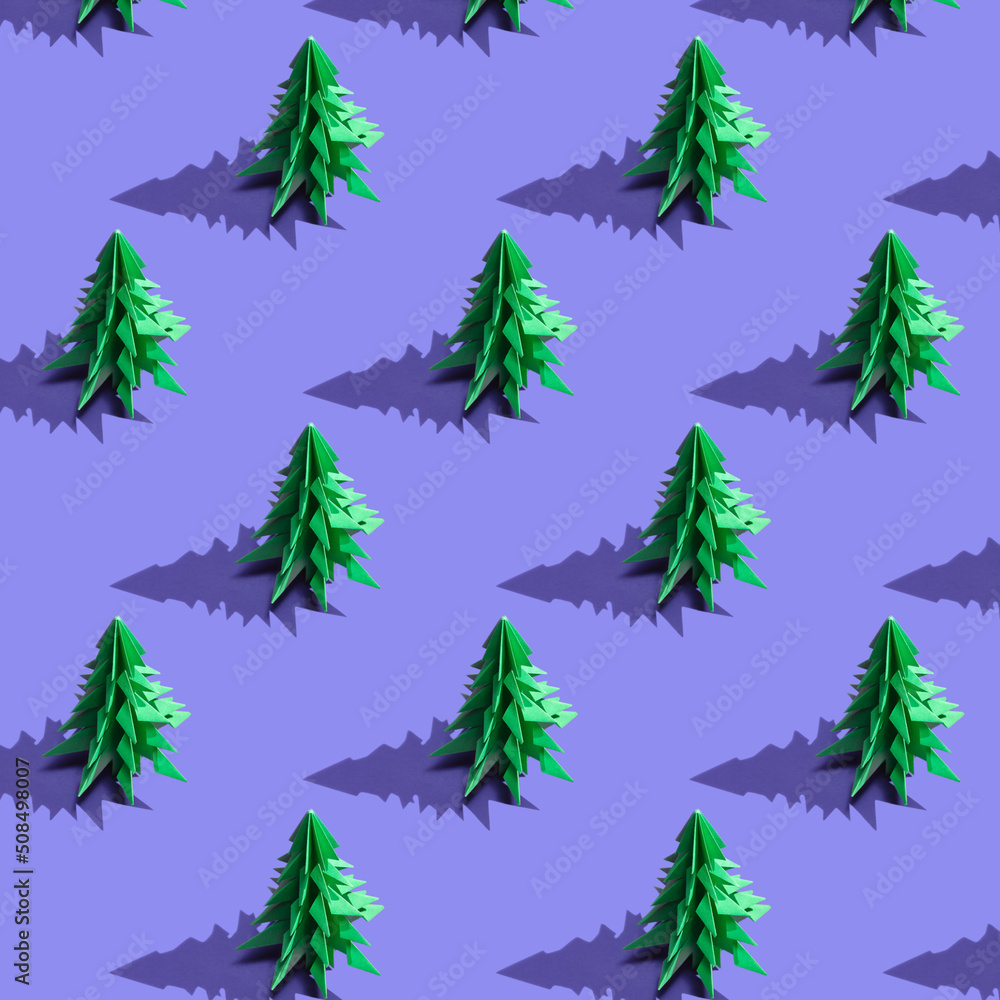 Seamless pattern with green christmas trees on the backdrop of the trendy 2022 color of the year Very Peri. Paper cut Christmas trees. Minimal pattern background of Christmas trees. New year concept