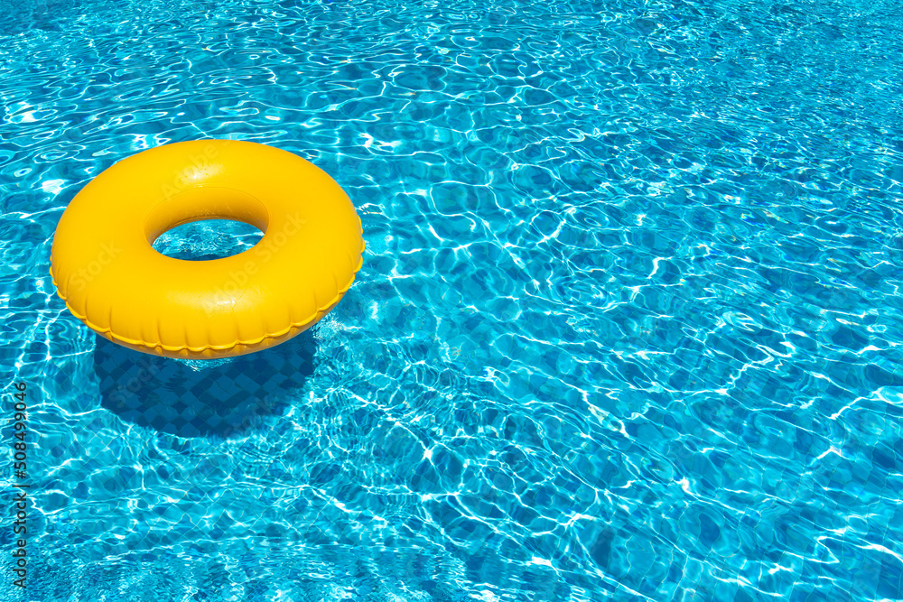 Yellow ring floating in blue swimming pool. Inflatable ring, rest concept - obrazy, fototapety, plakaty 