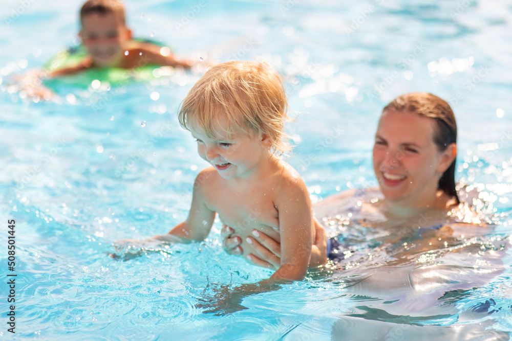 Mother with her son having fun in the swimming pool. Classes for babies. Family time