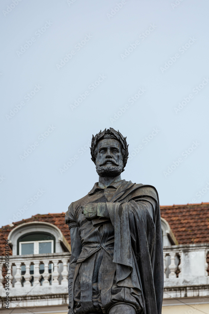 Statue of Luis de Camoes, with a house behind, in Lisbon, Portugal