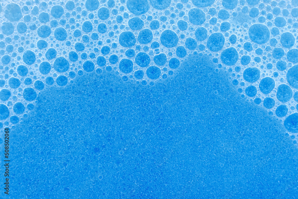 Soap foam in blue close-up. Foam bubbles on the surface of detergent or shampoo