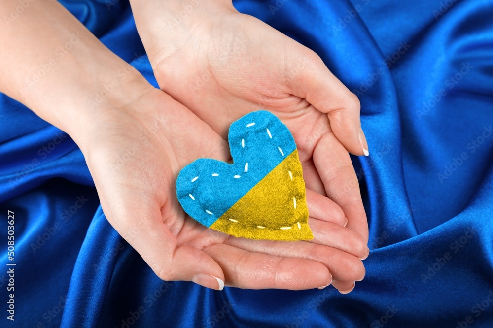 Hand with heart in colors of Ukrainian flag. Stop war in Ukraine concept . Hand with heart in colors of Ukrainian flag. Stop war in Ukraine concept .