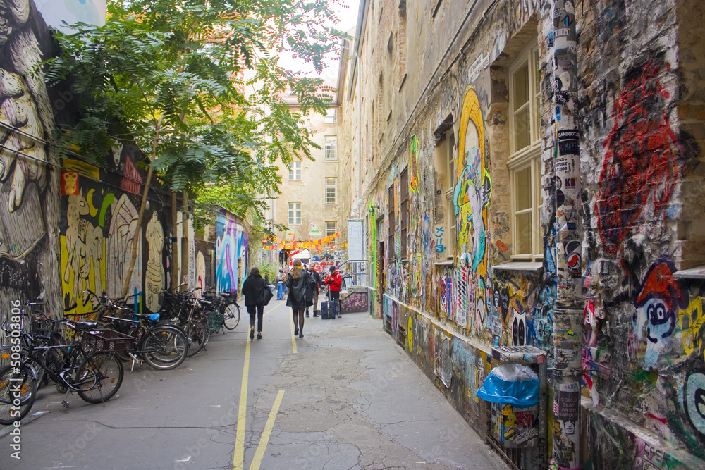 Haus Schwarzenberg - Street Art Alley with narrow passage next to a cafe leads to a courtyard exploding with murals in Berlin, Germany