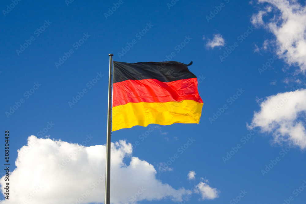 German flag in front of the blue sky German flag in front of the blue sky