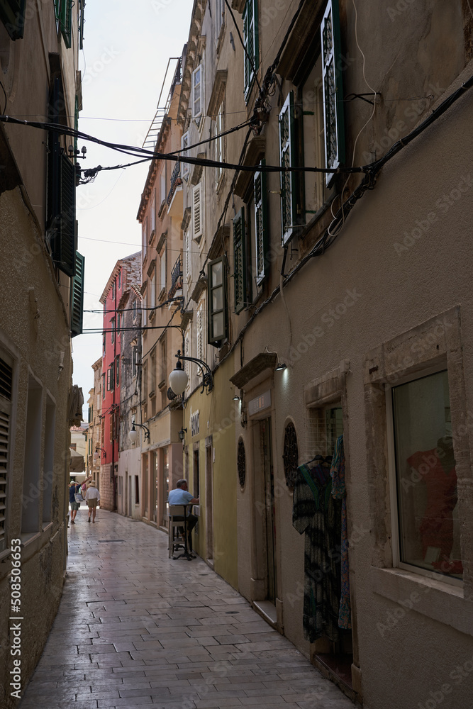 Fototapeta premium Sibenik, Croatia - May 26, 2022 - narrow old street and yard in Sibenik city, medieval zone