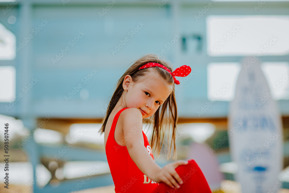 Pretty Little Girl In Red Bikini Posing With Small Surfboard Like A pretty-little-girl-in-red-bikini-posing-with-small-surfboard-like-a