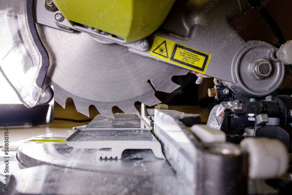 Worker cutting baseboard on the circular saw before installing - obrazy, fototapety, plakaty 