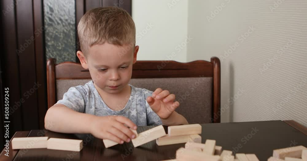 little boy playing with wooden blocks little boy playing with wooden blocks