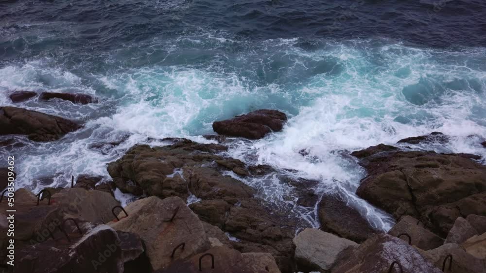 The waves of the ocean crash against the rocks. The waves of the ocean crash against the rocks.