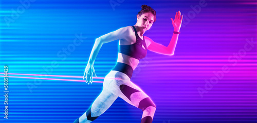Fitness woman performs exercises with resistance band on neon background