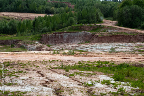 Red clay quarry. Clay quarry. Earth rocks are digging for building materials. Beautiful natural landscape to the land. Quarry with sand  sand loading  ground water