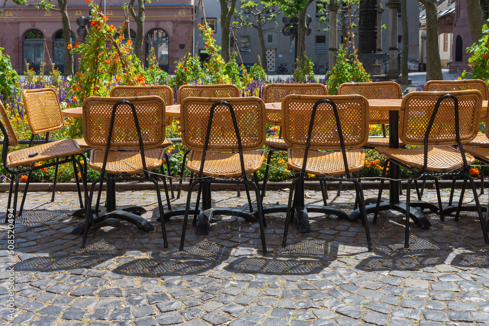 chairs and tables in front of a cafe in a city