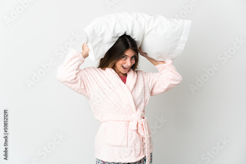 Young caucasian woman isolated on white background in pajamas and holding a pillow stressed overwhelmed