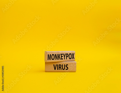Monkeypox virus symbol. Concept word Monkeypox virus on wooden blocks. Beautiful yellow background. Medicine and Monkeypox virus concept. Copy space